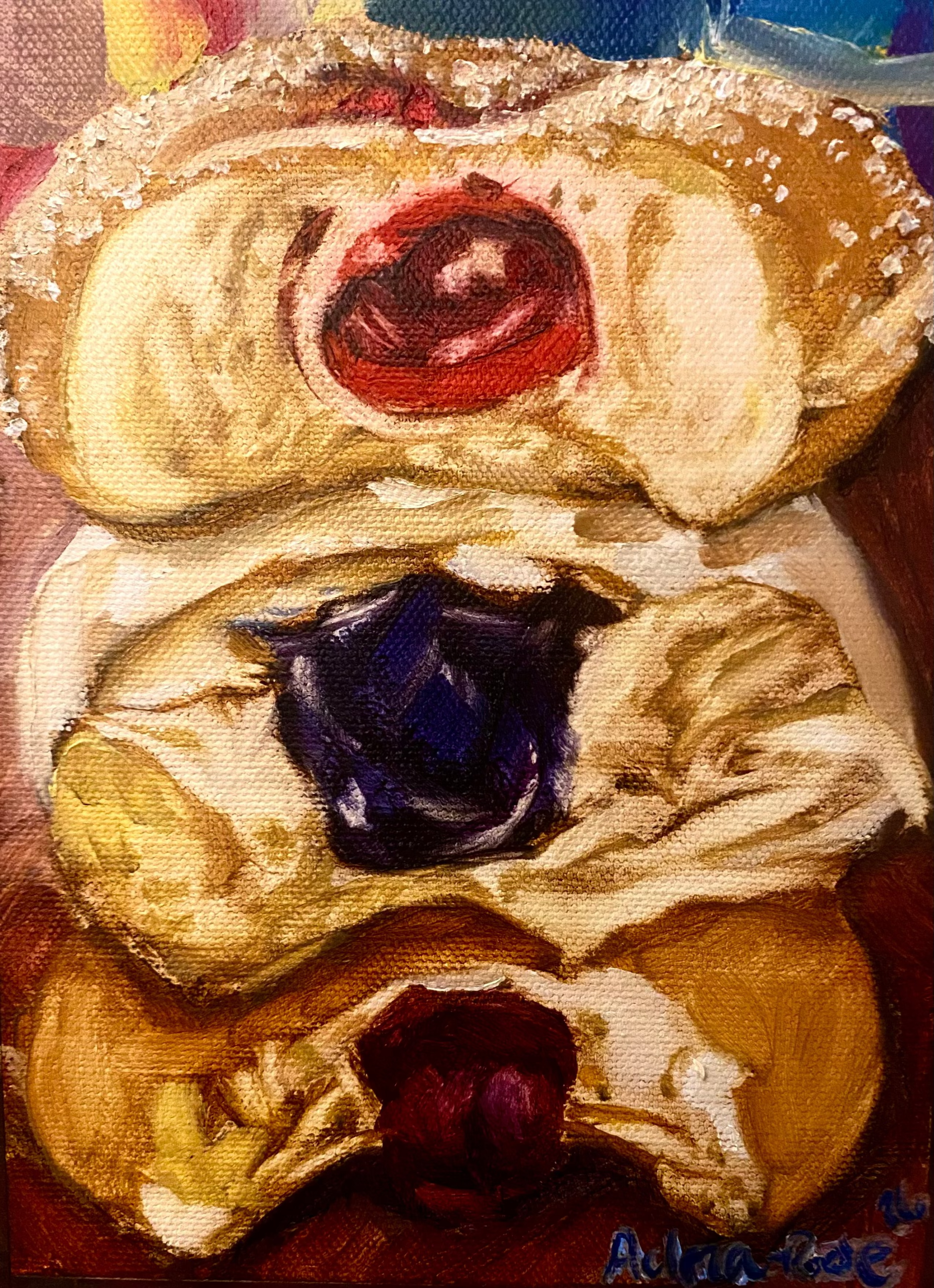 Close-up of an oil painting pastry with red and blue filling on a wooden surface